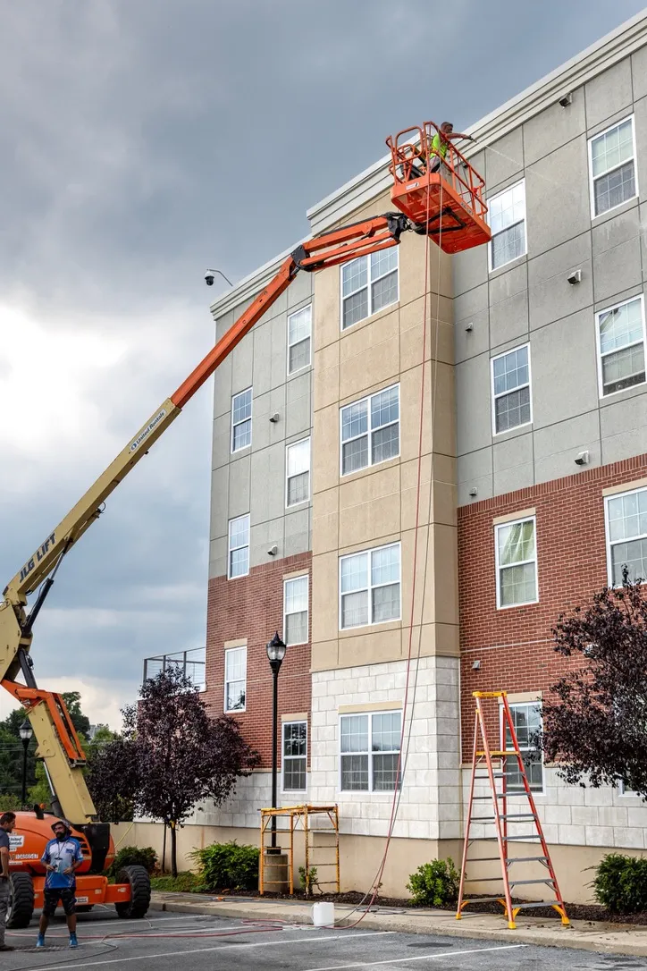 Boom lift exterior cleaning of a four-story apartment building by MJK Solutions in the Hudson Valley