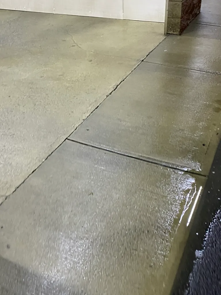 Concrete walkway shown half cleaned, with the dark untreated side next to the freshly surface-cleaned side, Dutchess County, NY
