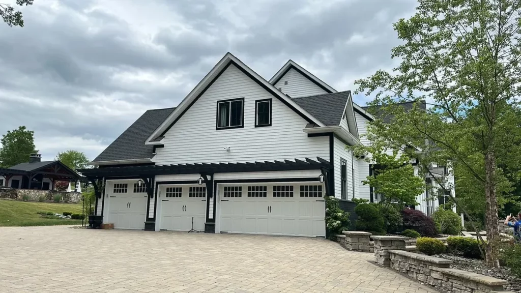 Clean paver driveway and white farmhouse-style home in the Hudson Valley after exterior cleaning by MJK Solutions