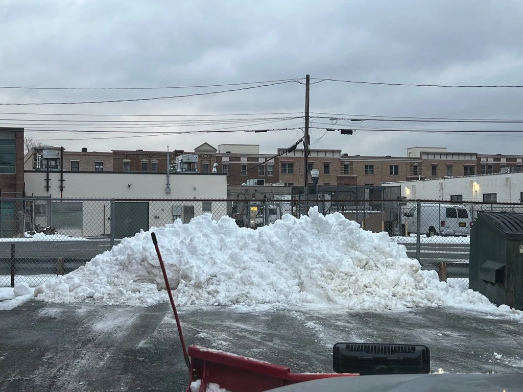 MJK Solutions plow pushing a snow pile in a commercial parking lot in Dutchess County, NY