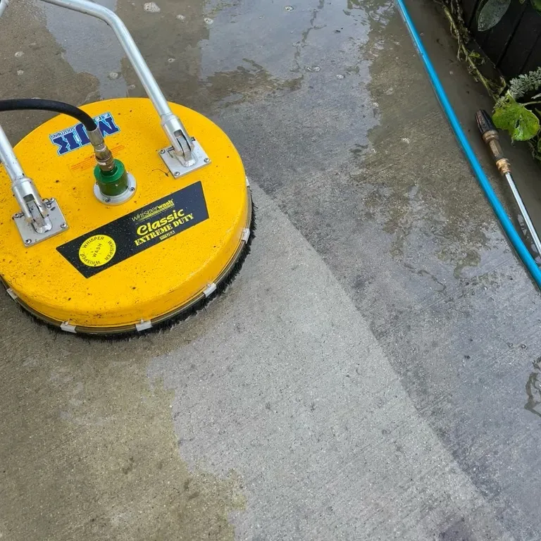 Rotary surface cleaner lifting grime from a concrete walkway during professional concrete cleaning in Poughkeepsie, NY